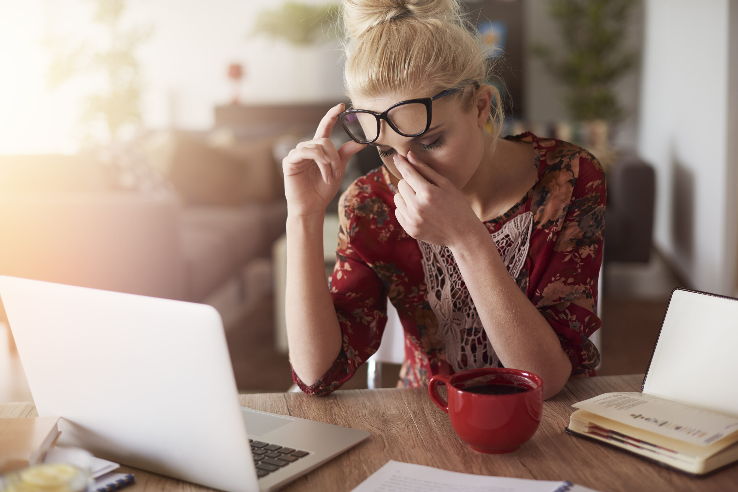 Gestresste Frau mit Brille am Schreibtisch – Symbolbild für chronische mentale Erschöpfung